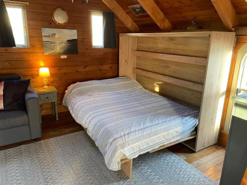PorkellisにあるEnys Boathouseの木造キャビン内のベッド1台が備わるベッドルーム1室を利用します。