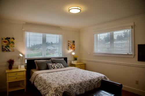 a bedroom with a bed and two windows at Scenic Lake View Home in Tacoma