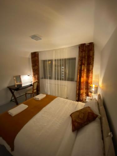 a bedroom with a large bed in a room with a desk at Hollemeadow in Bloxwich