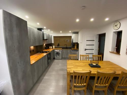 a kitchen with a wooden table and chairs at Hollemeadow in Bloxwich