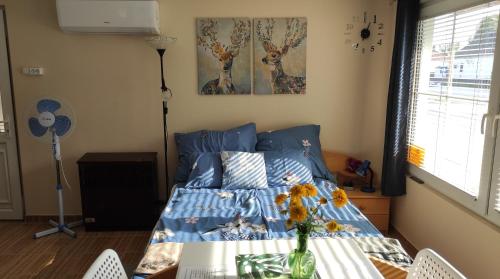 - une chambre avec un lit et un vase de fleurs sur une table dans l'établissement Fenyves-lak, à Szalkszentmárton