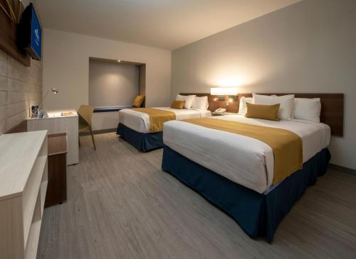 Una cama o camas en una habitación de Microtel Inn & Suites by Wyndham Guadalajara Sur