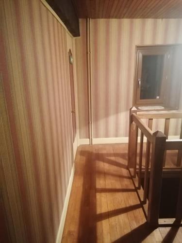 - un couloir doté de parquet et d'une fenêtre dans l'établissement Sam Bott, à Chambon-sur-Voueize