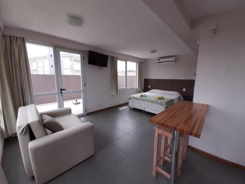 Sala de estar con sofá, cama y mesa en Cabañas Agreste en Villa Gesell