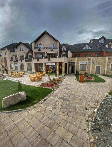 a large building with a patio in front of it at Pleasure Lux MILMARI-Kopaonik in Kopaonik
