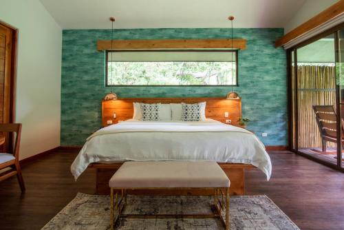 a bedroom with a large bed and a large window at El Silencio Lodge & Spa in Toro Amarillo