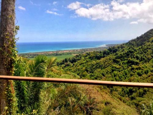 a view of the ocean from a hill with trees at Finca Cuipo in Buritaca