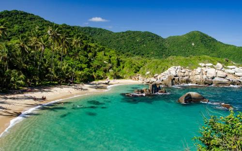 a beach with a group of people in the water at Finca Cuipo in Buritaca