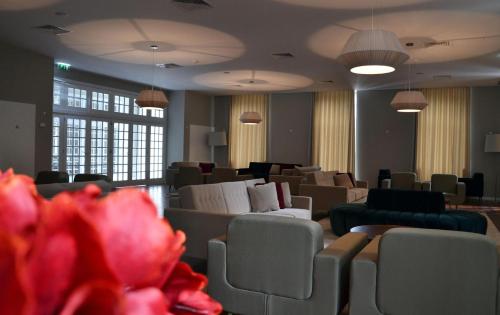 a waiting room with chairs and tables and lights at Hotel do Parque in Braga