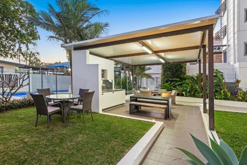 a patio with a table and chairs and a canopy at Coco Mooloolaba in Mooloolaba