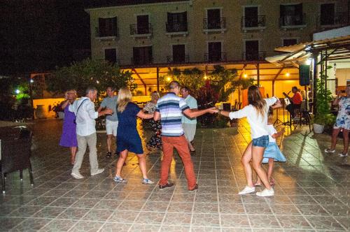 um grupo de pessoas dançando em uma rua à noite em Karavados Beach Hotel em Karavádhos