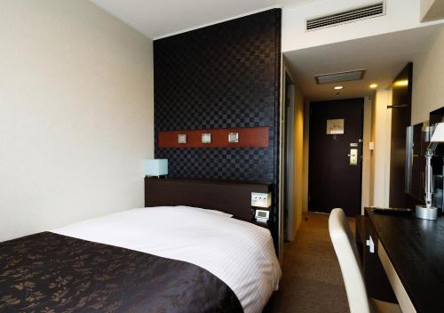 a hotel room with a bed and a desk at APA Hotel Kokura Ekimae in Kitakyushu