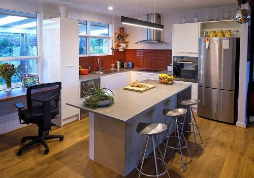 a kitchen with a large island with bar stools at Oasis at Aldinga Beach in Aldinga Beach
