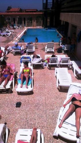 a group of people laying on lawn chairs near a pool at Hotel Chbat in Bcharré