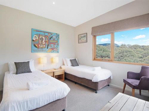 a hotel room with two beds and a window at Les Perrieres Chalet in Jindabyne