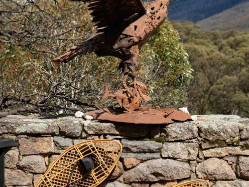 a statue of an eagle on top of a stone wall at Les Perrieres Chalet - Spacious 2BR Chalet l Gym l Indoor Pool l Tennis l WiFi l BBQ in Jindabyne