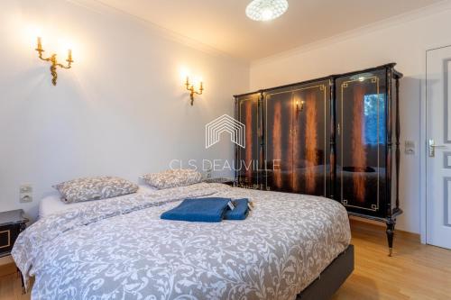- une chambre avec un lit et une serviette bleue dans l'établissement La Plaisance C.L.S Deauville, à Touques