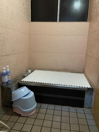 a small bathroom with a toilet in a stall at Lodge Oakland in Shinano