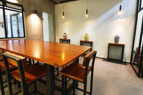 マラッカにある[New!] Jonker Street Loft 3BR Melaka 10PAXの椅子付きの部屋内の大きな木製テーブル