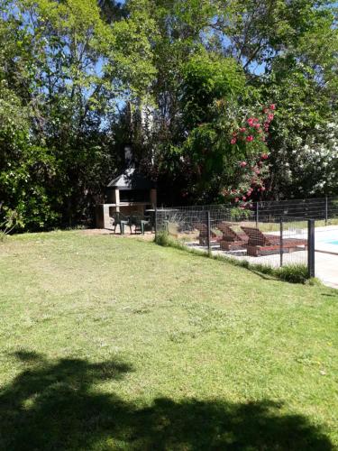 a park with a fence and a picnic table at La casita en el parque in Chacras de Coria