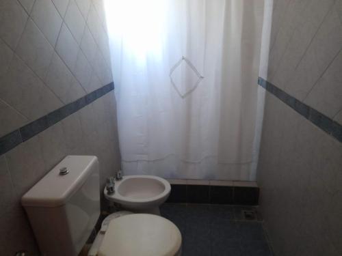 a small bathroom with a toilet and a sink at Departamentos Las Grutas Enjoy in Las Grutas