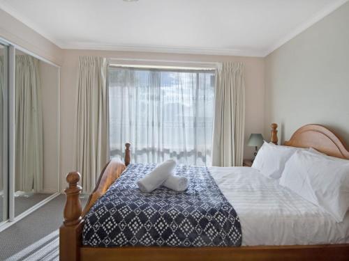 a bedroom with a bed and a large window at Beloka 7 Free WiFi in Jindabyne