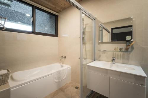 a bathroom with a tub and a sink and a shower at 花蓮Cozy Inn舒適窩民宿 in Hualien City