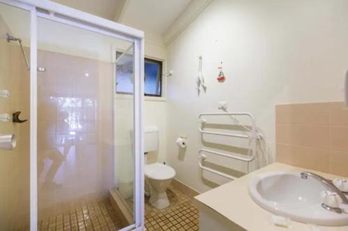 a bathroom with a shower and a sink and a toilet at Sandpiper On Smiths Lake in Smiths Lake