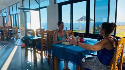 two women sitting at a table in a restaurant at The Marine Pride Beach Resort & Spa in Varkala