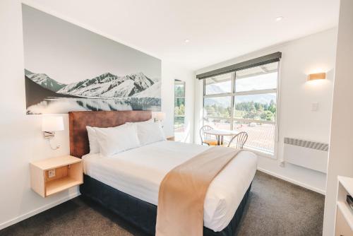 a bedroom with a large bed and a window at Blue Peaks Lodge in Queenstown