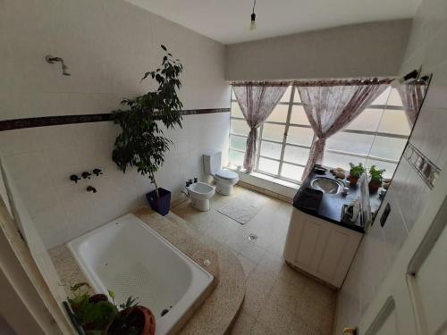 uma casa de banho com uma grande banheira, um lavatório e um lavatório. em ND nuestro destino em Cafayate