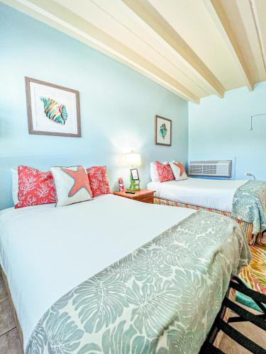 Dos camas en una habitación con paredes azules. en The Ocean View Inn, en Islamorada