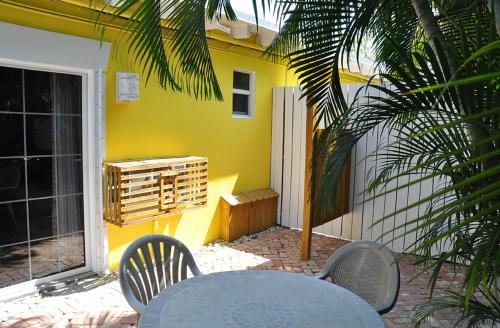 een tafel en stoelen voor een geel huis bij The Ocean View Inn in Islamorada