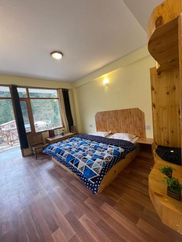 1 dormitorio con 1 cama y suelo de madera en The Mad King's House & Cafe, en Manali