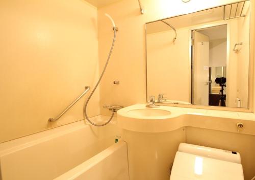 a bathroom with a sink, toilet and bathtub at APA Hotel Kokura Ekimae in Kitakyushu