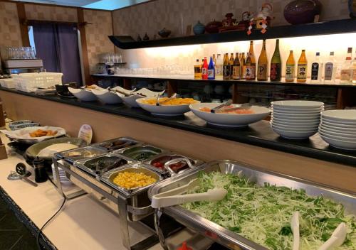 a buffet line with plates and bowls of food at APA Hotel Kokura Ekimae in Kitakyushu