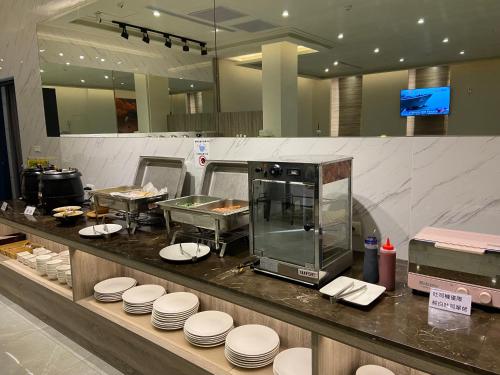 una cucina di un ristorante con piatti bianchi sul bancone di Purple Rainbow Motel a Taipei
