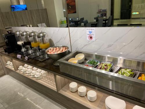 una linea a buffet con cibo e bevande in un ristorante di Purple Rainbow Motel a Taipei