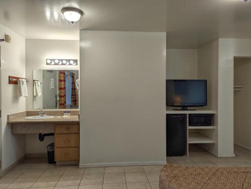 a bathroom with a sink and a tv in a room at Americas Best Value Inn Oxnard-Port Hueneme in Port Hueneme