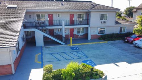 an apartment building with a staircase in a parking lot at Americas Best Value Inn Oxnard-Port Hueneme in Port Hueneme