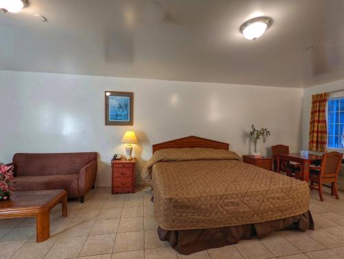 a bedroom with a bed and a couch and a table at Americas Best Value Inn Oxnard-Port Hueneme in Port Hueneme
