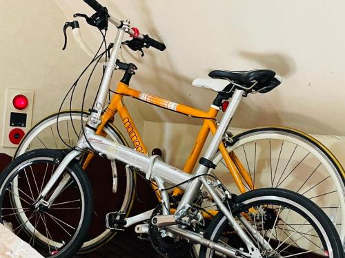 an orange bike is leaning against a wall at 宮古島サイクリストの宿 in Miyako Island