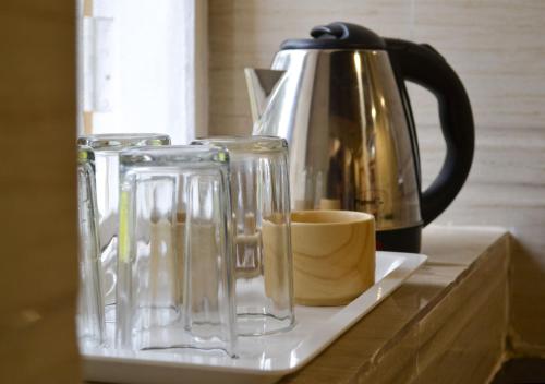 zwei Glasvasen und eine Kaffeekanne auf der Theke in der Unterkunft Citadel Resort in Panchgani