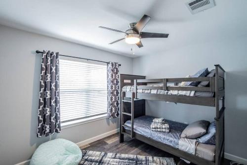 - une chambre avec 2 lits superposés et un ventilateur de plafond dans l'établissement Newly Minted Bungalow, near Austin, à Manor