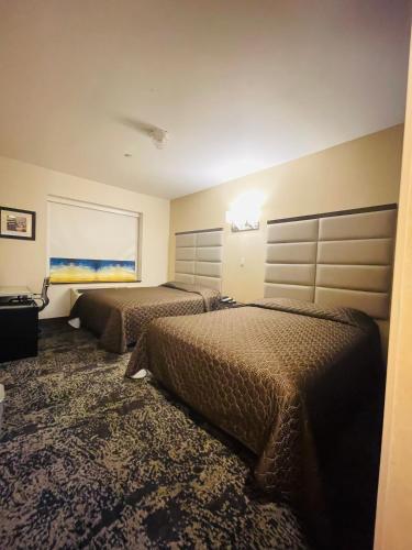 a hotel room with two beds and a window at 7 Days Hotel in Bronx