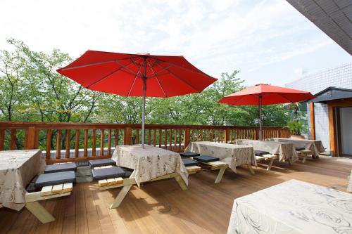 a deck with tables and umbrellas on a deck at Day Nice Hotel Tokyo in Tokyo