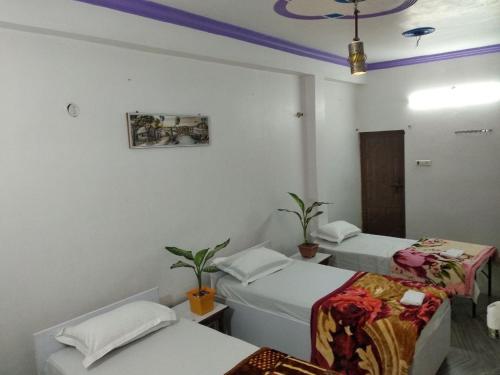 Habitación con 2 camas y espejo. en Videep house, en Kānpur