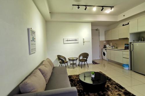 a living room with a couch and a table and a kitchen at Happy Holiday,I-Soho, I-City, Shah Alam ,Free Wifi & Parking in Shah Alam