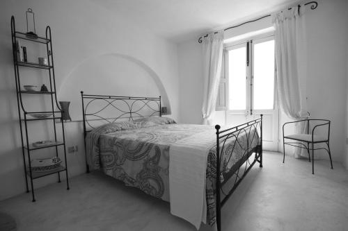 サンタ・マリーナ・サリーナにあるLa Casa di Via Lungomareの黒と白のベッドルーム(ベッド1台、椅子付)