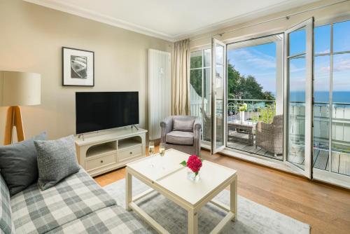 a living room with a couch and a tv at Hotel Residenz Waldkrone Kühlungsborn in Kühlungsborn